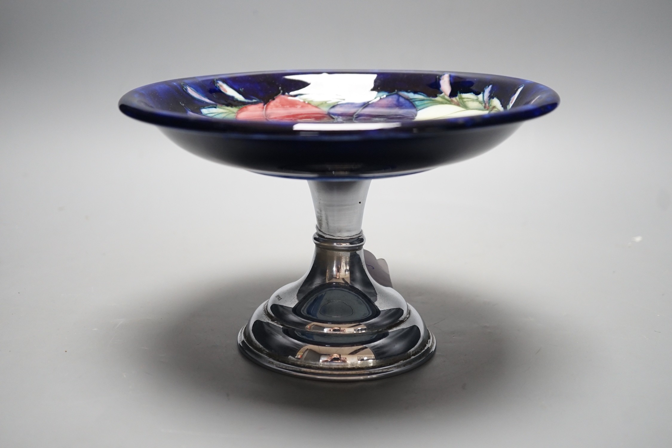 A Moorcroft wisteria pattern cake stand with chrome pedestal, 21cm diameter